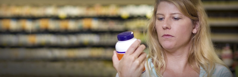 Woman in store reading a supplement bottle