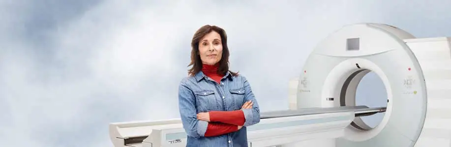 Kathy in front of CT machine for Saved By the Scan campaign