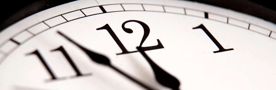 Analog clock shows hands at 11:55