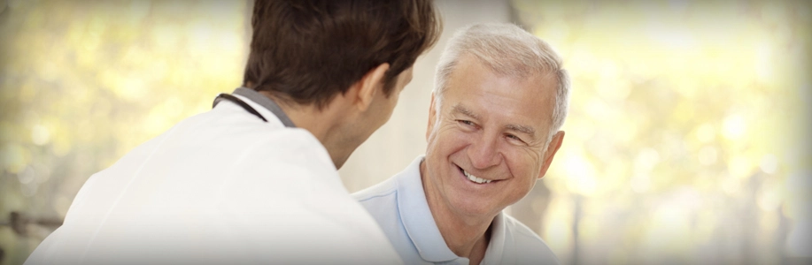 Doctor talks to older man who is smiling
