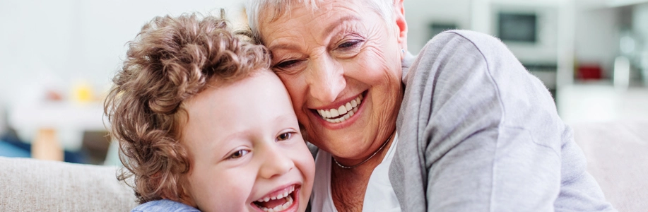 Older adult woman hugging young child